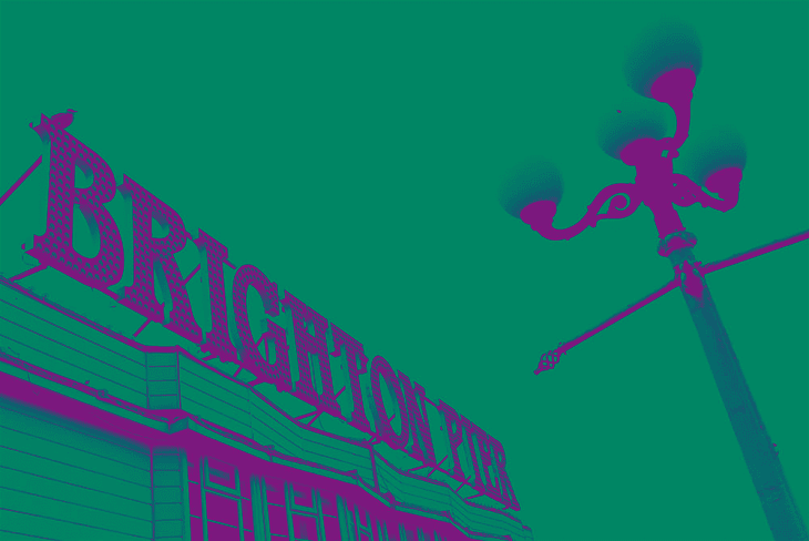 Brighton Pier sign with vintage streetlamp against sky